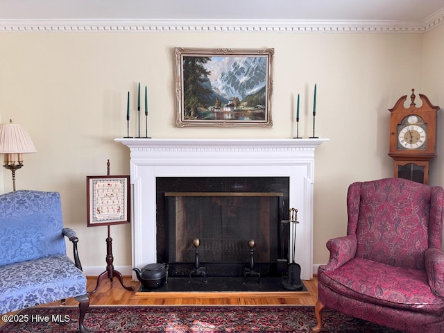 sitting room with hardwood / wood-style flooring and ornamental molding