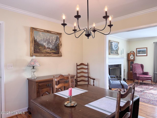 dining room with ornamental molding, a notable chandelier, and light hardwood / wood-style floors