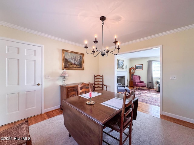 dining room with ornamental molding and light hardwood / wood-style floors