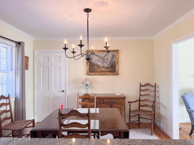 dining area with crown molding, a chandelier, and light wood-type flooring