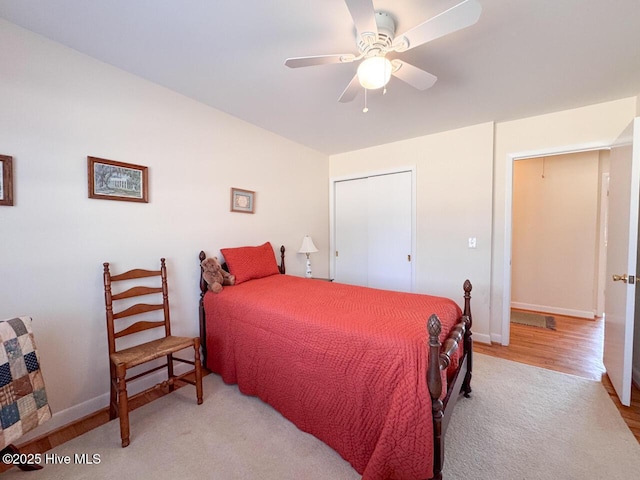 bedroom featuring ceiling fan, light hardwood / wood-style floors, and a closet