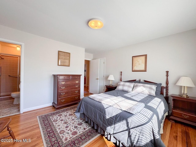 bedroom with ensuite bathroom and light hardwood / wood-style floors