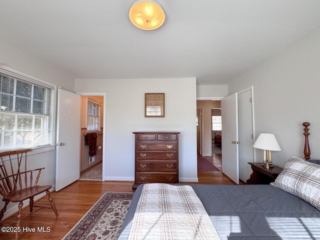 bedroom featuring multiple windows, hardwood / wood-style flooring, and ensuite bathroom