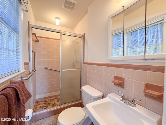 bathroom featuring tile walls, sink, toilet, and walk in shower