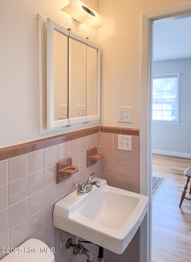 bathroom featuring hardwood / wood-style flooring, sink, and tile walls