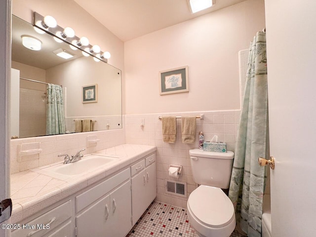 bathroom featuring tile walls, vanity, tile patterned flooring, and toilet