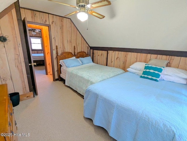 carpeted bedroom with ceiling fan, lofted ceiling, and wooden walls