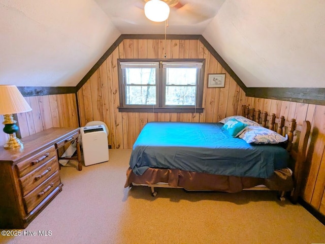 bedroom featuring lofted ceiling, light carpet, ceiling fan, and wood walls