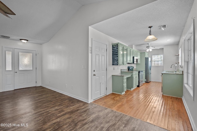 foyer entrance with sink, vaulted ceiling, a textured ceiling, dark hardwood / wood-style floors, and ceiling fan