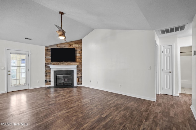 unfurnished living room with a large fireplace, lofted ceiling, and dark hardwood / wood-style floors