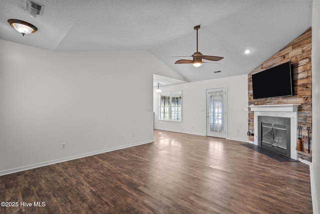 unfurnished living room with ceiling fan, dark hardwood / wood-style flooring, vaulted ceiling, and a textured ceiling