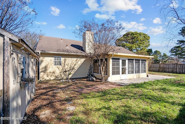 back of house with a sunroom and a yard