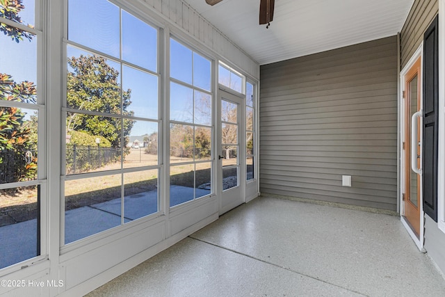 unfurnished sunroom featuring ceiling fan