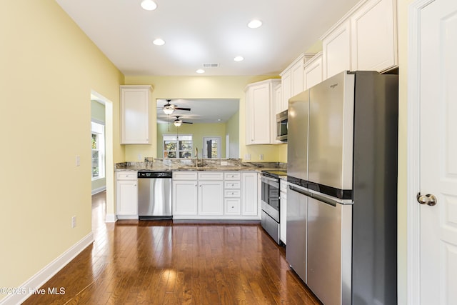 kitchen featuring sink, white cabinetry, appliances with stainless steel finishes, dark hardwood / wood-style flooring, and light stone countertops