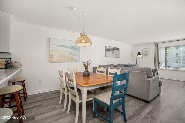 dining room featuring baseboards, ornamental molding, and dark wood-style flooring