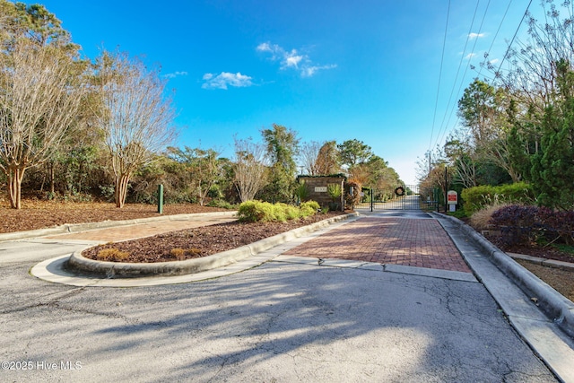 view of road with curbs and a gate