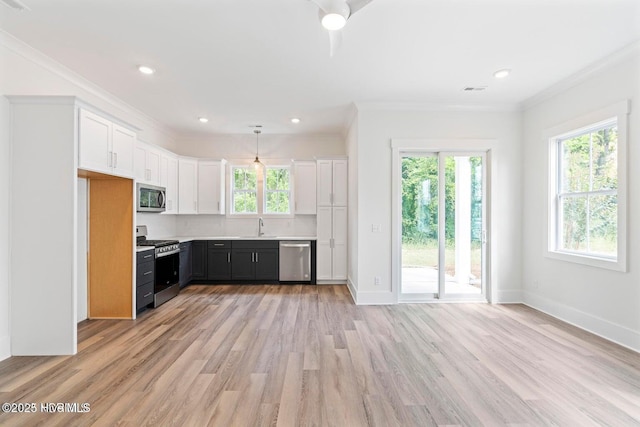 kitchen featuring white cabinetry, ornamental molding, stainless steel appliances, and decorative light fixtures