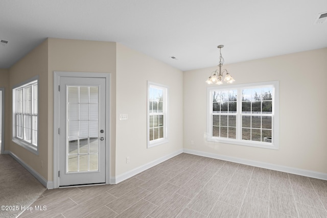 unfurnished dining area featuring an inviting chandelier