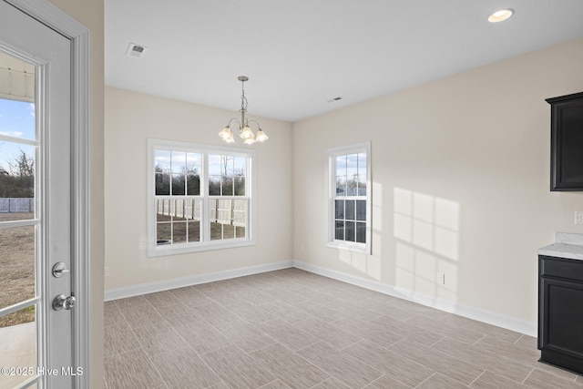 unfurnished dining area featuring a notable chandelier