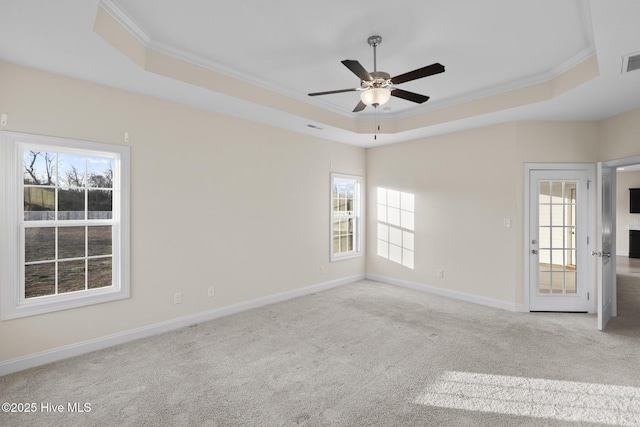 unfurnished room with ornamental molding, light colored carpet, ceiling fan, and a tray ceiling