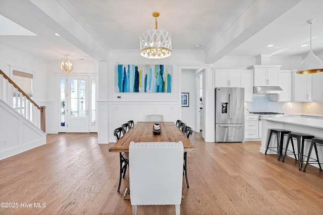 740 Waterstone Dr, Wilmington, NC 28411 - dining room featuring a chandelier, light wood-style flooring, a decorative wall, ornamental molding, and stairway