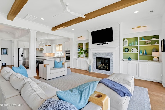 740 Waterstone Dr, Wilmington, NC 28411 - living area with beamed ceiling, light wood-style flooring, a ceiling fan, recessed lighting, and a high end fireplace