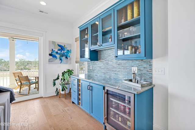 740 Waterstone Dr, Wilmington, NC 28411 - indoor wet bar featuring beverage cooler, tasteful backsplash, light wood-style floors, and baseboards