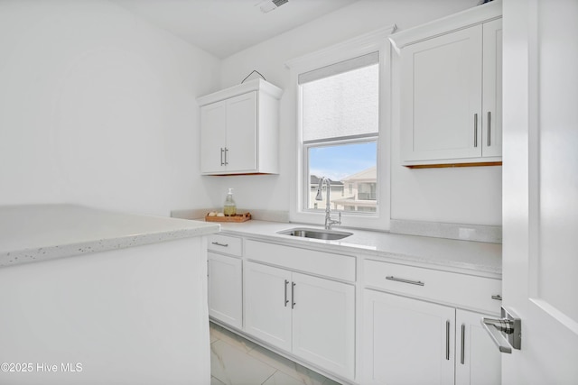 740 Waterstone Dr, Wilmington, NC 28411 - kitchen featuring a sink, white cabinets, and light marble finish floors