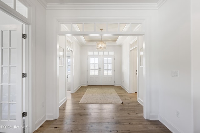 entryway featuring ornamental molding, a notable chandelier, and hardwood / wood-style floors