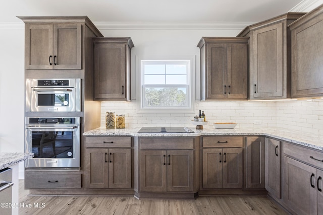 kitchen with stainless steel double oven, crown molding, backsplash, black electric cooktop, and light stone countertops