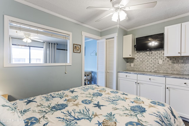 bedroom with crown molding, ceiling fan, a textured ceiling, and a closet