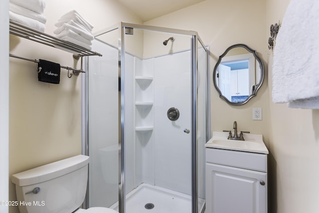 bathroom featuring an enclosed shower, vanity, and toilet