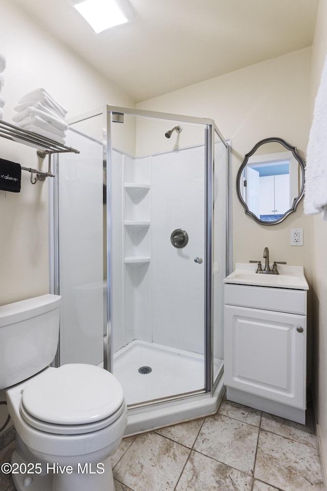 bathroom featuring vanity, toilet, and a shower with door