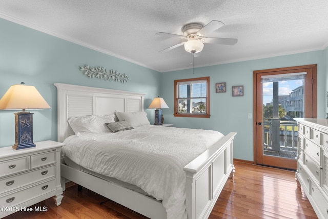 bedroom with a textured ceiling, ornamental molding, light wood-style flooring, and access to exterior