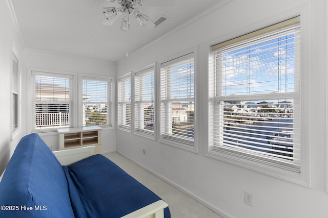 sunroom with a ceiling fan and visible vents