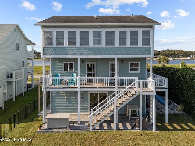 rear view of property with stairway, a patio area, fence, and a lawn