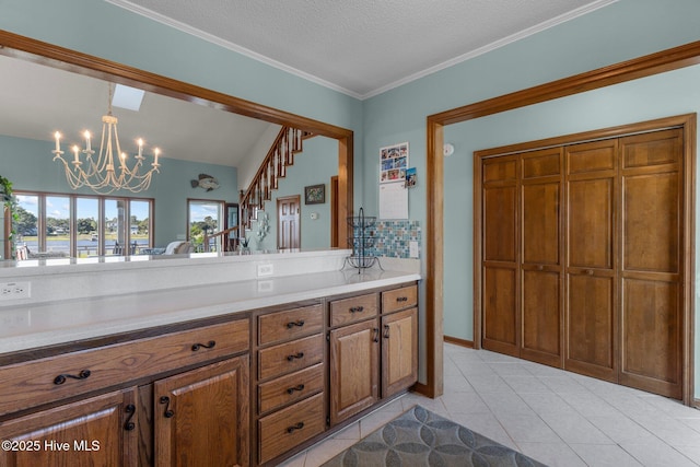 bathroom featuring a chandelier, ornamental molding, a textured ceiling, and tile patterned flooring