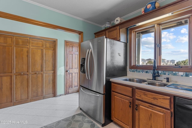 kitchen featuring light tile patterned floors, a sink, stainless steel refrigerator with ice dispenser, brown cabinets, and dishwasher