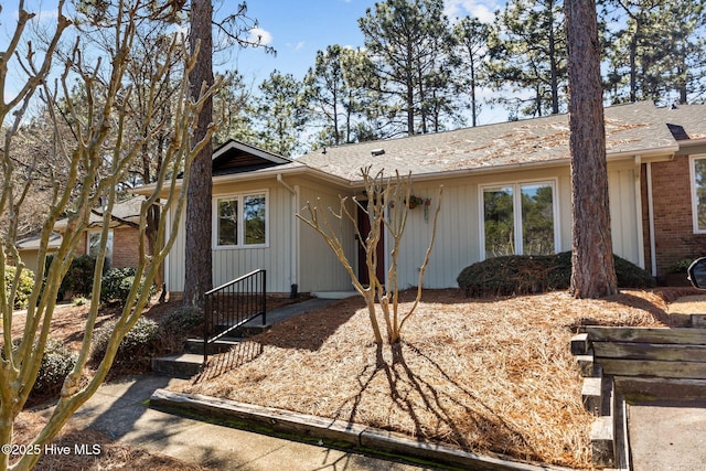 ranch-style home with brick siding and roof with shingles