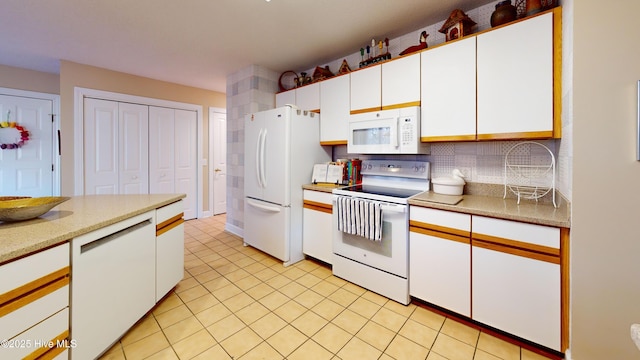 kitchen with white cabinetry, backsplash, white appliances, and light tile patterned floors