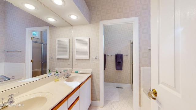 bathroom with tile patterned floors, vanity, and a washtub