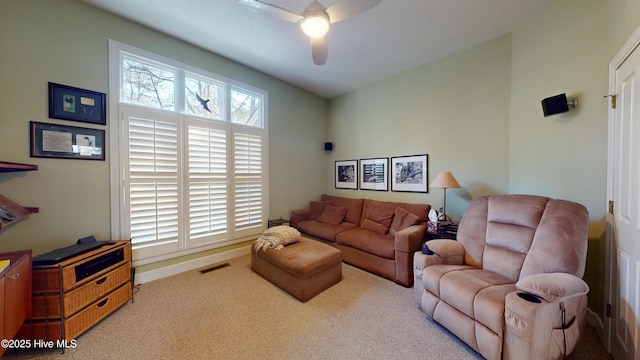 carpeted living room with ceiling fan