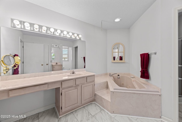 bathroom with vanity, tiled bath, and a textured ceiling