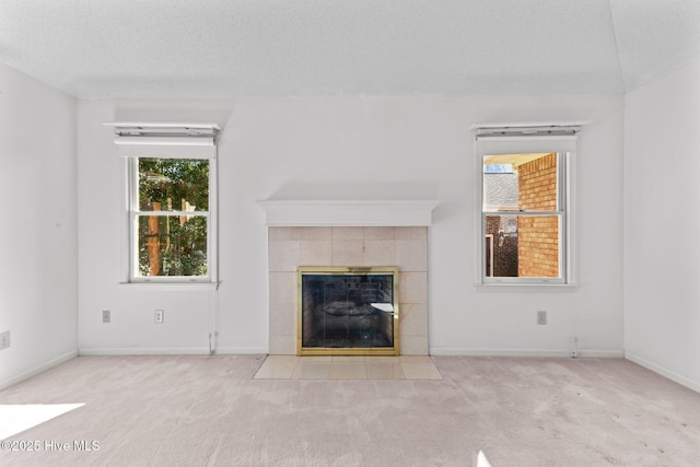 unfurnished living room with a fireplace, light carpet, and a textured ceiling