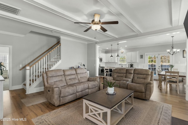 living room with sink, crown molding, light hardwood / wood-style floors, beam ceiling, and ceiling fan with notable chandelier