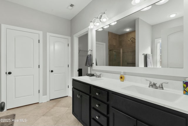 bathroom featuring tile patterned flooring, vanity, and a shower with shower door