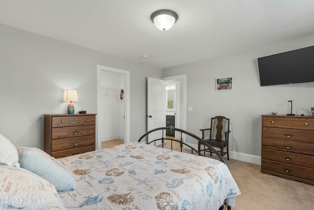 bedroom featuring a spacious closet, light colored carpet, and a closet