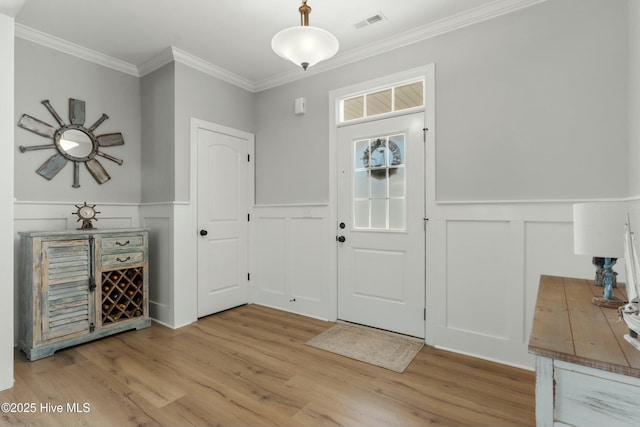 entryway featuring crown molding and light hardwood / wood-style flooring