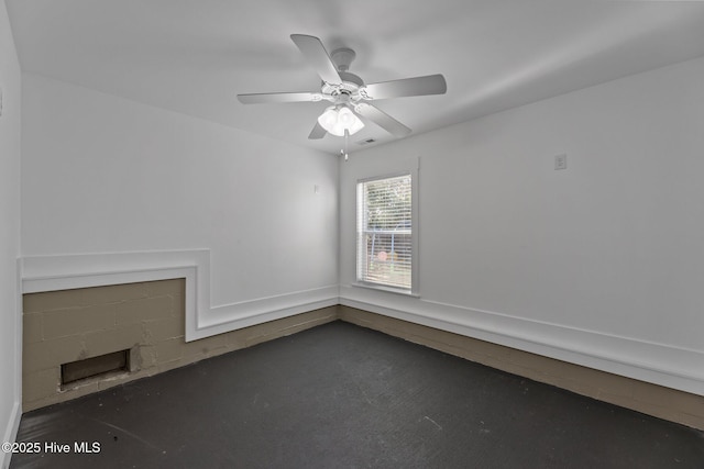 empty room with ceiling fan and dark colored carpet