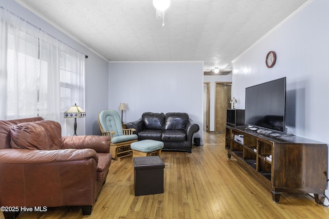 living room with crown molding and light wood-type flooring